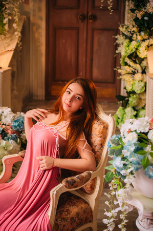 A young girl in a luxurious dress with a long train and an open back. Creative colors.の写真素材