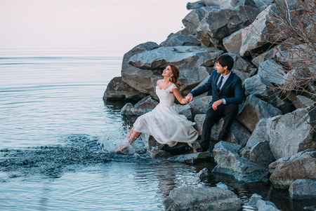 Stylish wedding on the river bank. Walk of lovers at sunset. A beautiful love story. Film colors.の写真素材