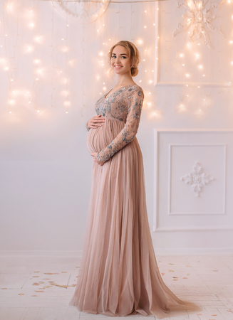 Lovely young pregnant woman in a beautiful dressの写真素材