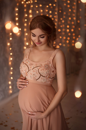 Lovely young pregnant woman in a beautiful dressの写真素材