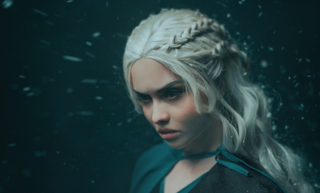 Portrait of a blonde girl close up. Background dark with flying snow, ash. White hair with creative braiding. Emotions of anger, and madness. The gothic queen on a deep winter night. Art photoの写真素材