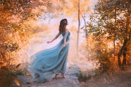 Beautiful woman wearing blue turquoise dress in the forestの写真素材