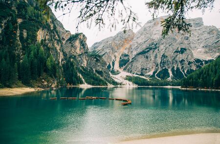 Free space for an inscription of text poster on backdrop of alpine Lake Braies boats turquoise water white road leading top majestic mountains green forest fantastic nature no people. Photo wallpaperの写真素材