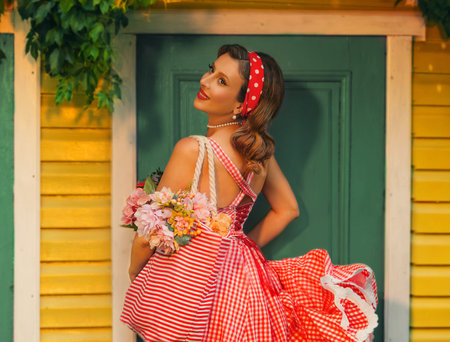 fantasy art portrait happy retro lady pin up style hairdo red lips holiday make-up, hand waving dress smiling face woman standing at door of house yard green ivy. Vintage style blonde girl back viewの写真素材