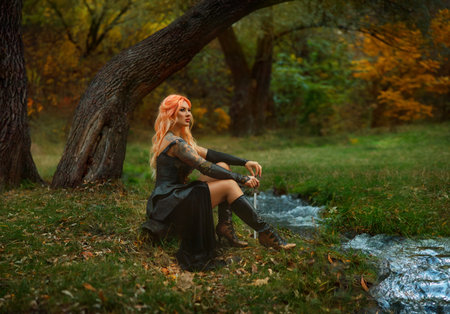 art photo real person, girl warrior holds sharp dagger knife. strong lady dangerous fantasy heroine woman assassin dress leather suit armor, cold steel short sword. Forest nature river water.の写真素材