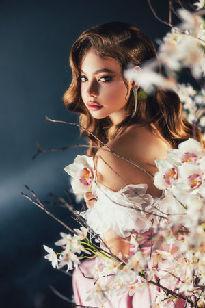 art photo real person beauty face elf girl green eyes, sexy fantasy woman holiday makeup pink lips long loose blonde hair wavy curls white luxury dress spring tree night garden flowers goddess natureの写真素材