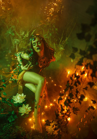 Portrait river nymph fairy fantasy woman beauty face eyes holiday make-up black lips. night dark room full fog magic light glow shine. elf girl witch gothic style green dress halloween costumeの写真素材