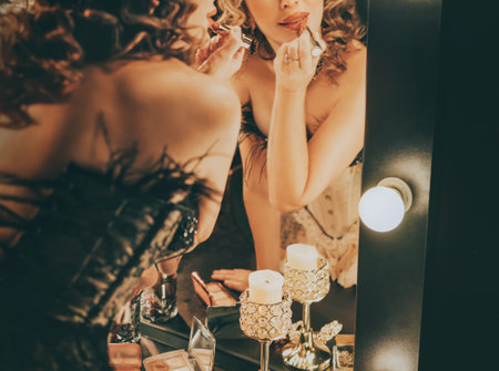 close-up shot body part mouth of blonde hair retro lady looking into mirror painting lips with lipstick gloss cosmetics. woman burlesque show actress, preparing makeup. Flapper girl 20s old styleの写真素材