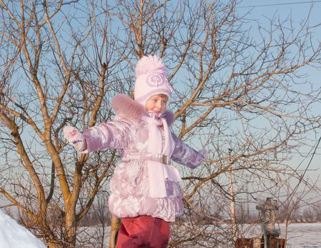 Happy little girl on winter landscape backgroundの写真素材
