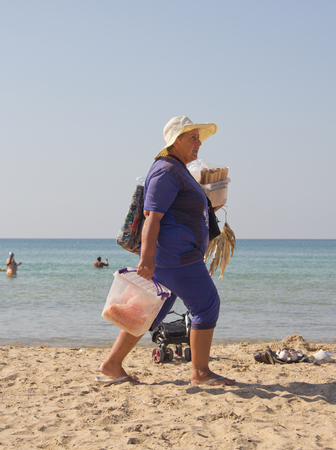 Anapa, Russia - September 27, 2015: Woman on the beach selling sweet cakesのeditorial素材