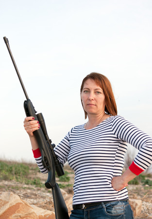 Portrait of middle aged woman with rifleの写真素材