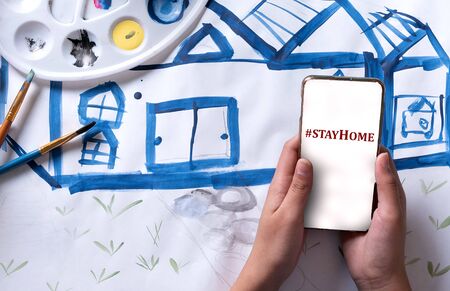 Painting at home, and chatting with her touch screen smartphone, during Prevention epidemic.