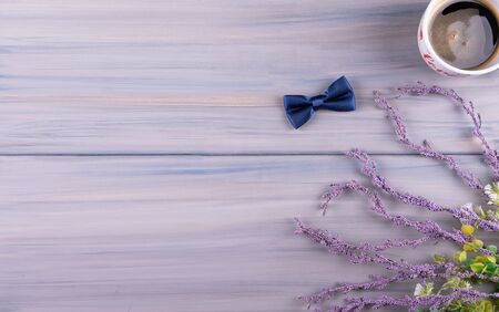 Happy birthday greeting card concept father's day or anniversary on wood table background, Bow tie, coffee cup,  with flowers. Top view.の写真素材