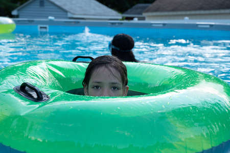 Pretty girl playing in the pool during summer time.の写真素材
