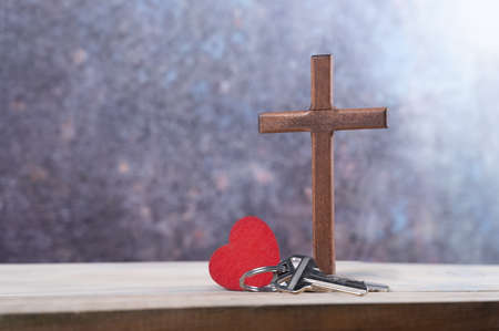 House keys with Wooden cross next to small red Heart on white background. copy spaceの写真素材