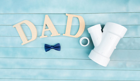 Father's day concept surrounded by plumber pipe tools, Bow tie and space for text on blue background. copy spaceの写真素材