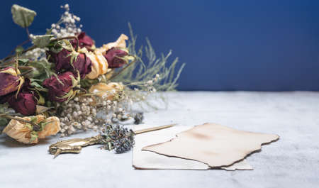 Spring bouquet of dried flowers with Steel letter opener and Empty Blank Paper, on vintage background. Selective focus. copy space.の写真素材