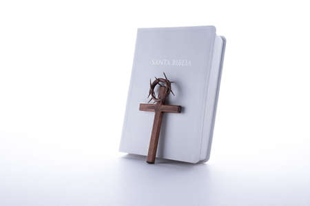 Crown of thorns, bible and wood cross on white background. Easter or Resurrection concept. He is Risen. Spanish text lettering .の写真素材