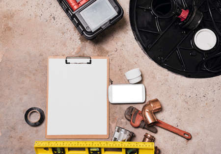 Blank page notepad and Mobile phone mock up screen next to Sump Pumps, Work tools and pipeline equipment with copy space.の写真素材