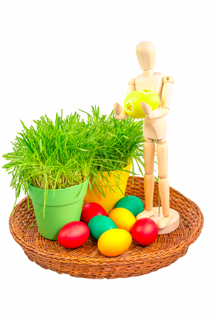 Mannequin holding an Easter egg surrounded by pots with grass and colorful eggsの写真素材