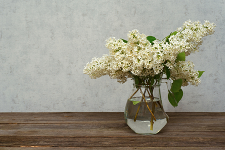 White lilac in a vase on a wooden table, it is tinted under sepiaの写真素材