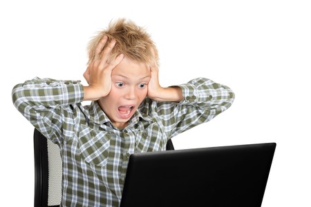 Emotions on a face of the boy during the work with the laptopの写真素材