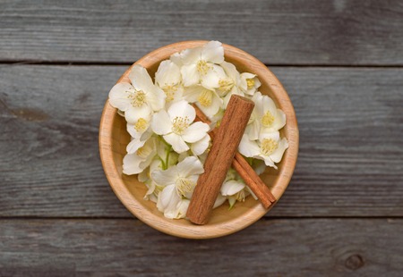 Jasmine flowers for tea and cinnamon. Old wooden table.の写真素材