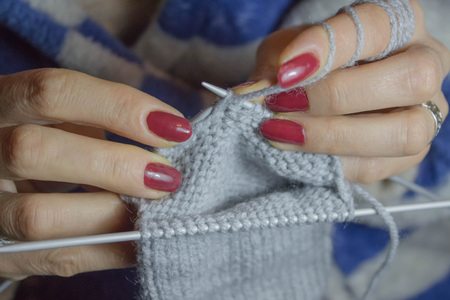 Close-up of hands knitting. Detail of the hands of an crocheting. Woman knitting small socksの写真素材
