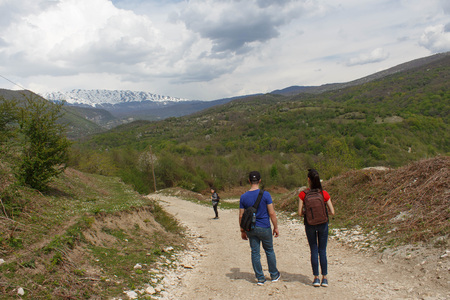 Travelers travel on the road in mountains go trekking Countryside, village - mountains, Clouds. Active hikersの写真素材