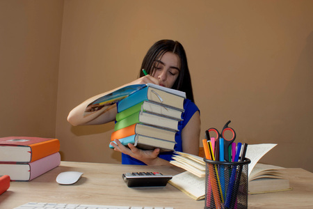 Girl doing her homework. Education and school concept - little student girl with many books - books...