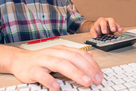 Businessman working on office desk with Calculator, a computer, a pen and papers. Businesses concept...
