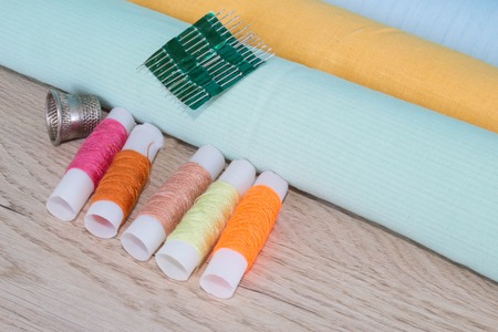 Sewing still life: colorful cloth. Sewing kit includes threads of different colors, thimble and...