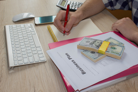 person Man pointing writing goals on a paper,writing business plan at workplace, man holding pens, papers, notes in documents, Saving money conceptの写真素材