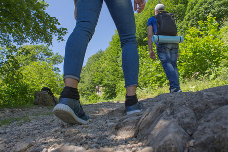 Travelers travel on the road in mountains go trekking together. Trekking together. Travel adventure and hiking activity, active and healthy lifestyle on summer vacation and weekend tourの写真素材