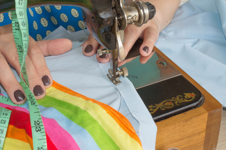 Woman hand on sewing machine.Dressmaker work on the sewing machine. Hobby sewing fabric as a small...