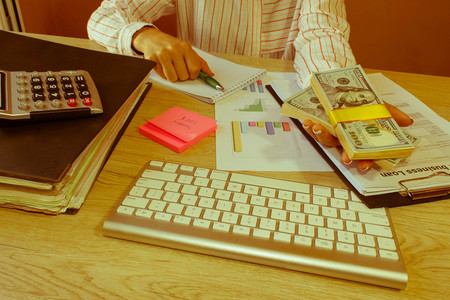 Businesswoman offering batch of hundred dollar bills. Hands close up. Loan, credit, debt concept. Hand giving money - Retro colorの写真素材