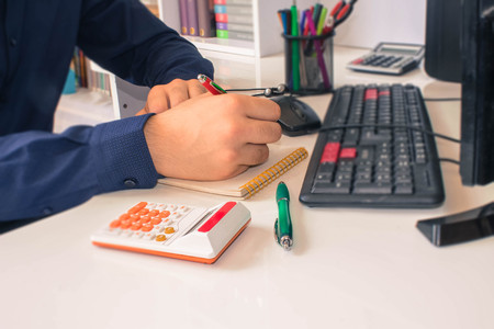 Close up view of bookkeeper or financial inspector hands making report, calculating or checking balance. Home finances, investment, economy, saving money or insurance conceptの写真素材