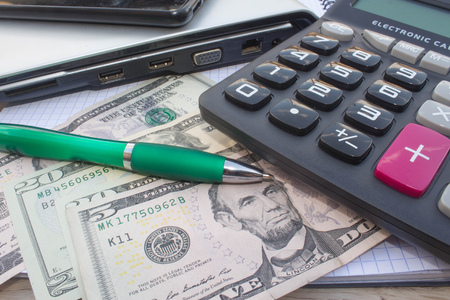 Stock market table analysis, calculator and pen indicates research and analysis, with cash. Money and a calculatorの写真素材