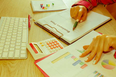 Close-up of a spreadsheet with pen and calculator. view of bookkeeper or financial inspector hands...