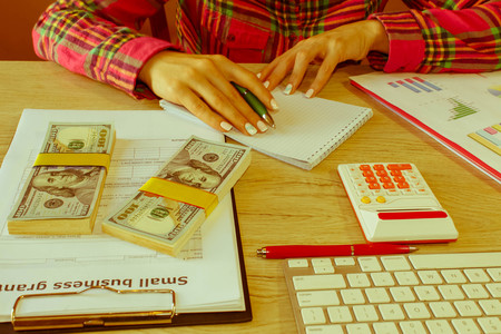 Savings, finances, grant, economy and home concept - Female with calculator, money and making notes...