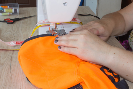 designer making a garment in her workplace. seamstress sews clothes. Workplace of tailor - sewing...
