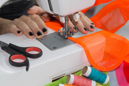 processes of sewing on the sewing machine sew women's hands sewing machine. Female tailor threading...