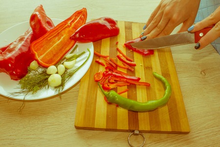 Young woman cooking healthy meal in the kitchen. Cooking healthy food at home. Woman in kitchen preparing vegetables - Retro colorの写真素材