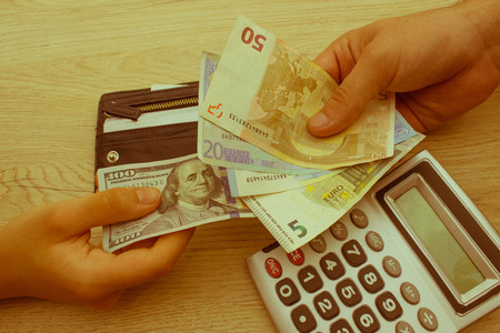 people, exchanging money, saving and finance concept - close up of male and female hands giving or exchanging money - Retro colorの写真素材