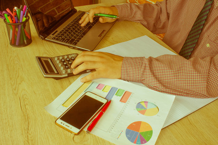 Businesspersons analyzing report, business performance concept. Young Businessman Calculating...
