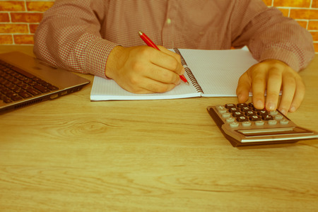 Businessman using a calculator to calculate the numbers. Accounting , Accountancy, Calculation Concept. Male using a tablet to analysis marketing - Retro colorの写真素材