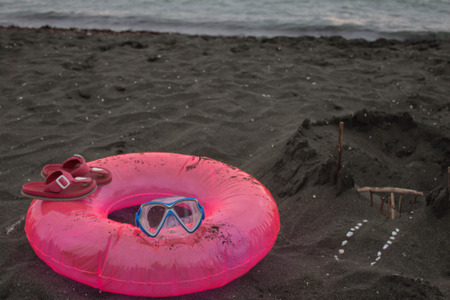 Sand castle, swimming glasses, Pink sandals and Floating Ring. summer and travel concept. Beach life. Travel or sea vacations conceptの写真素材
