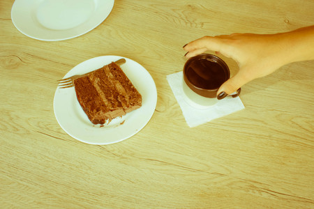 Woman having cake and coffee at the coffee shop. Eat chocolate cake with coffee in a relaxing time - Retro colorの写真素材