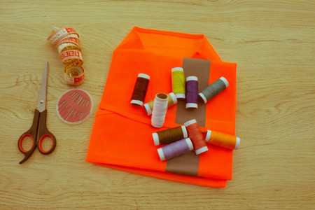 Sewing still life: colorful cloth. scissors and sewing kit includes threads of different colors,...