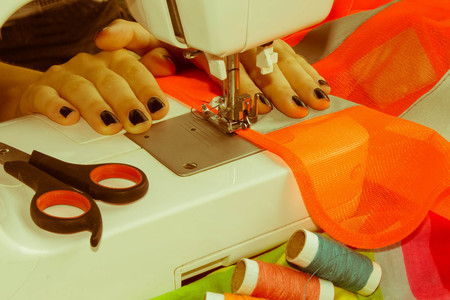 processes of sewing on the sewing machine sew women's hands sewing machine. Female tailor threading...